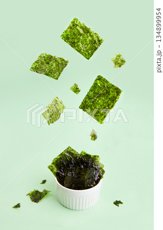 Flying crispy nori seaweed. Traditional Japanese dry seaweed sheets. Flying crispy nori seaweed. Traditional Japanese dry seaweed sheets. 134899954