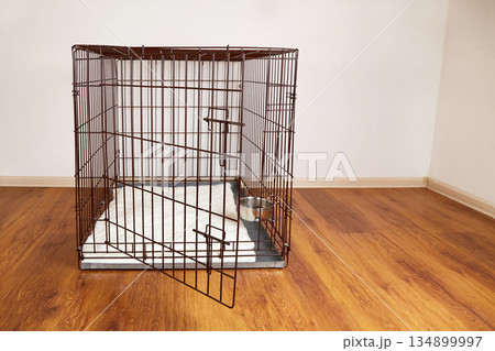 An empty cage for pets in an apartment. 134899997