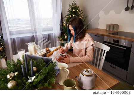A young girl cooks Christmas gingerbread at home in the kitchen. 134900068