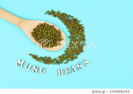 Mung beans in wooden spoon on a green background. 134900243