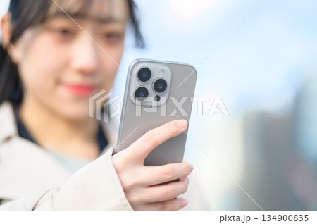 オフィス街でスマホを使用する日本人女性 134900835