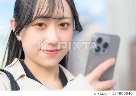 オフィス街でスマホを使用する日本人女性 オフィス街でスマホを使用する日本人女性 134900840