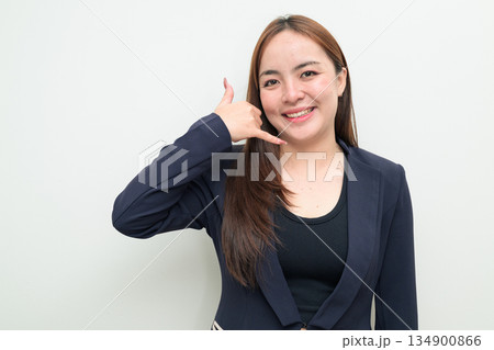 Portrait of a young Asian businesswoman against white background making call me phone hand gesture 134900866