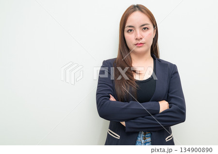 Portrait of a young Asian businesswoman against white background with arms crossed 134900890