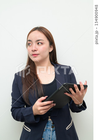 Portrait of a young Asian businesswoman against white background using digital tablet computer Portrait of a young Asian businesswoman against white background using digital tablet computer 134900948