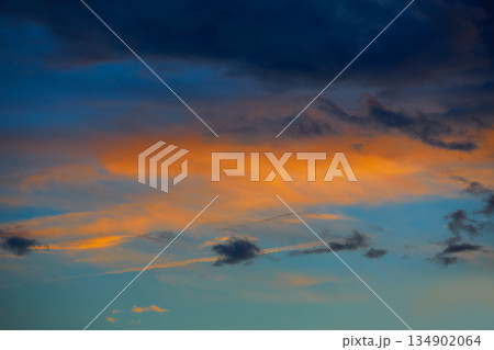 Sunset orange clouds in a blue sky Sunset orange clouds in a blue sky 134902064