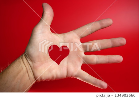Red heart shape drawed on a male human hand 134902660