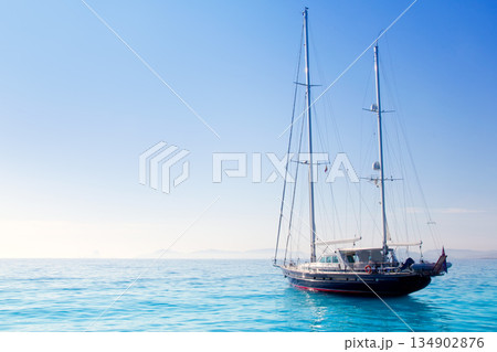 anchored sailboats in turquoise Formentera beach 134902876