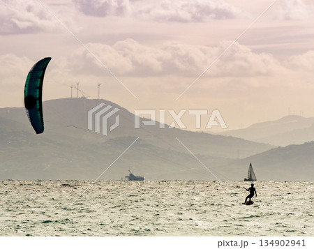 Kite surfer riding waves. Kiteboarding sport. 134902941