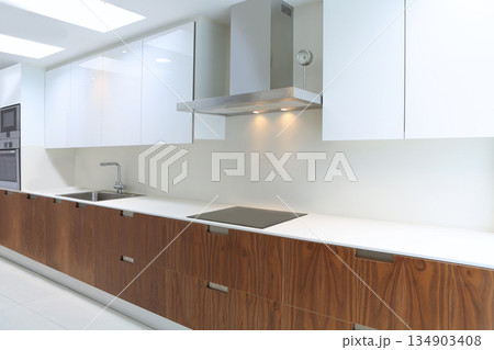 Actual modern kitchen in white and walnut wood Actual modern kitchen in white and walnut wood 134903408