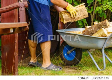 Man working with firewood. Man working with firewood. 134903430