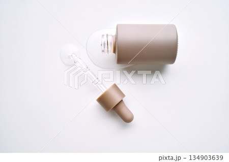 Skincare product packaging with spilled serum and pipette Skincare product packaging with spilled serum and pipette 134903639