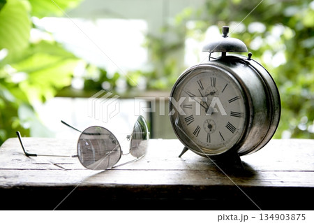Old alarm bell clock at the window backlit Old alarm bell clock at the window backlit 134903875