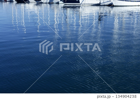 Sailboat blurred mast reflexion on the marina Sailboat blurred mast reflexion on the marina 134904238
