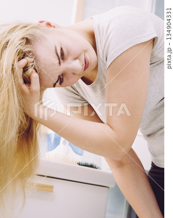 Female having problem with blonde hair 134904331