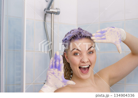 Woman applying toner shampoo on her hair 134904336