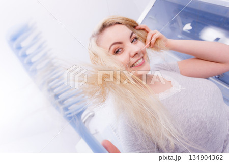 Woman brushing her wet blonde hair Woman brushing her wet blonde hair 134904362