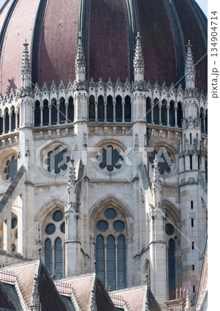 Ornate historic Budapest parliament building dome with neo-Gothic arches, stone carvings, and decorative window Ornate historic Budapest parliament building dome with neo-Gothic arches, stone carvings, and decorative window 134904714