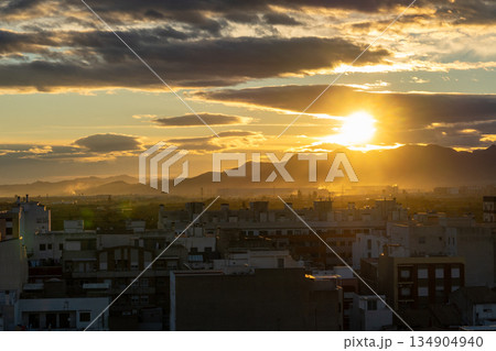 Golden hour sunset light over city skyline and mountains Golden hour sunset light over city skyline and mountains 134904940