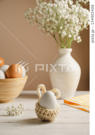 Easter eggs background. White eggs in wooden bowl and gypsophila flowers in a vase. Spring holiday 134905488