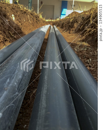 pvc pipes laid in parallel inside a trench in the ground 134905515
