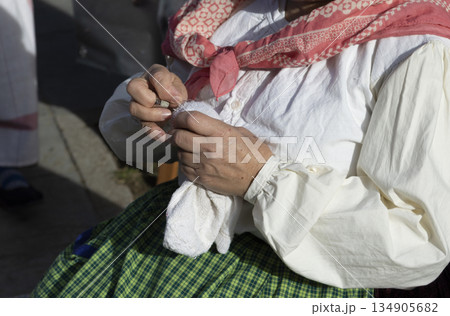 human hands sewing with metal thimble 134905682
