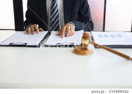 Legal counsel reading contract paperwork to finalize a legal agreement. Concepts for legal counsel, judicial authority, and the finality of a decision or agreement. 134906492