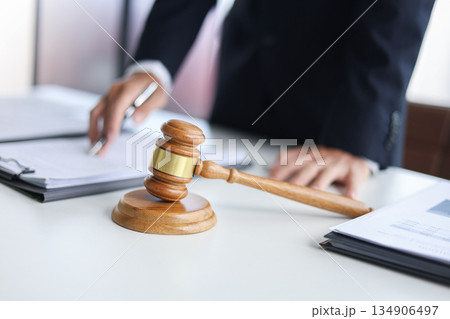 Legal counsel reading contract paperwork to finalize a legal agreement. Concepts for legal counsel, judicial authority, and the finality of a decision or agreement. 134906497
