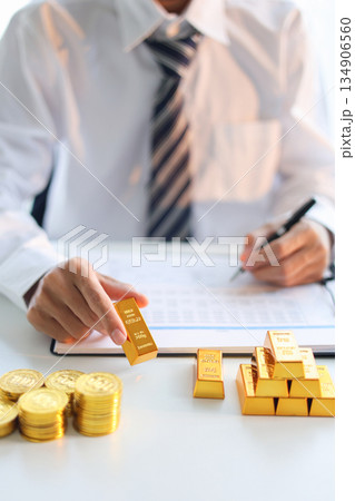 Gold bars on the table. Businessman invest in trading actual gold, calculating profit price of buy and sell gold. Gold bars on the table. Businessman invest in trading actual gold, calculating profit price of buy and sell gold. 134906560