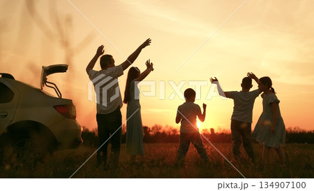 Happy family car trip, child parents picnic outdoor holiday, mother father kid dancing to music outdoors, people having fun, dancing across meadow, sunset dancing kids, bright orange sunset, weekend Happy family car trip, child parents picnic outdoor holiday, mother father kid dancing to music outdoors, people having fun, dancing across meadow, sunset dancing kids, bright orange sunset, weekend 134907100