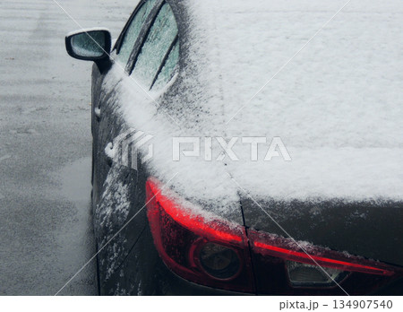 Snow and ice on the rear part of the car on the wet asphalt  134907540