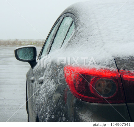 Rear back lights of grey car covered with snow and ice outdoor at winter day 134907541