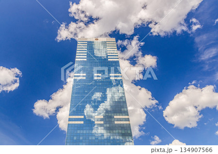 South Tower skyscraper modernism architecture style, modern high-rise office building, abstract details of facade glass curtain wall cells reflecting white clouds in blue sky, Brussels city, Belgium 134907566