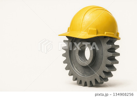 Yellow helmet on a cogwheel. Space for text. Yellow helmet on a cogwheel. Space for text. 134908256