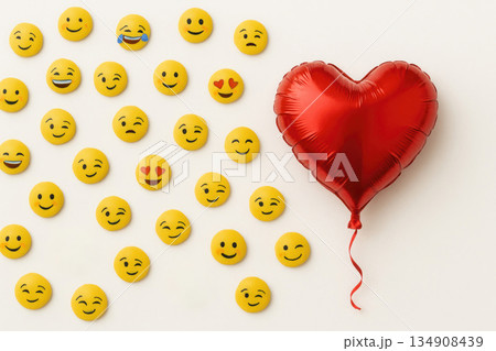 A red heart ball among yellow emojis on a light background. Space for text. A red heart ball among yellow emojis on a light background. Space for text. 134908439