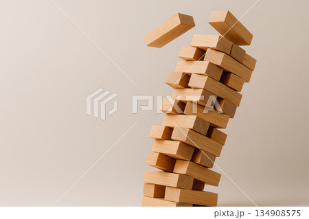 A tower made of wooden bars, losing its balance. Space for text. A tower made of wooden bars, losing its balance. Space for text. 134908575
