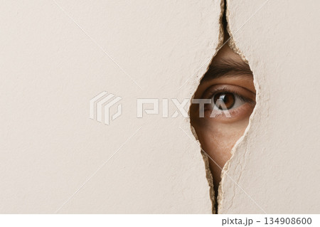 A photorealistic human eye peeking through a crack in the wall. Space for text. A photorealistic human eye peeking through a crack in the wall. Space for text. 134908600