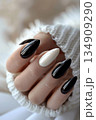 Closeup of black and white manicured nails with nail polish 134909290