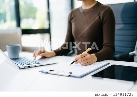 business documents on office table with smart phone and digital tablet and graph business with social network diagram and woman working in the office 134911725