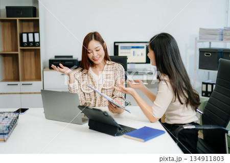Business team of two executives working together using laptop in office. young asian businesswoman Business team of two executives working together using laptop in office. young asian businesswoman 134911803