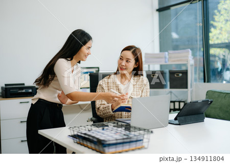 Business team of two executives working together using laptop in office. young asian businesswoman Business team of two executives working together using laptop in office. young asian businesswoman 134911804