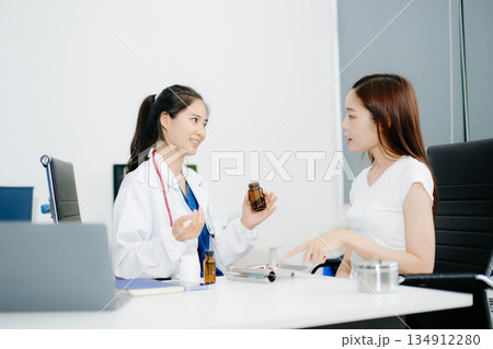 Female doctor explaining diagnosis to her patient. Doctor Meeting With Patient In Exam Room. 134912280