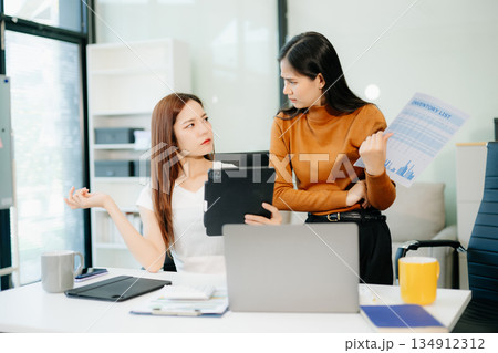 Business team of two executives working together using laptop in office. young asian businesswoman Business team of two executives working together using laptop in office. young asian businesswoman 134912312