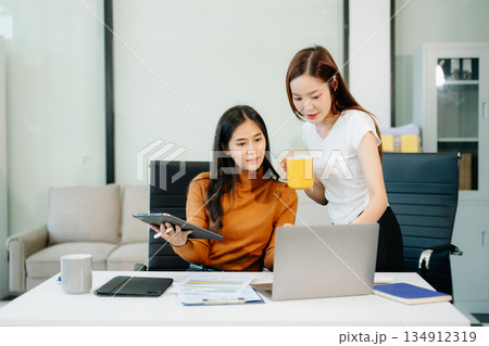 Business team of two executives working together using laptop in office. young asian businesswoman Business team of two executives working together using laptop in office. young asian businesswoman 134912319