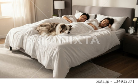 朝の光の中で犬と添い寝する若いカップルの穏やかな寝顔 134912371