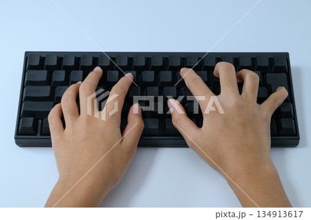 真上から見たキーボードをタイピングする子供の手元 真上から見たキーボードをタイピングする子供の手元 134913617