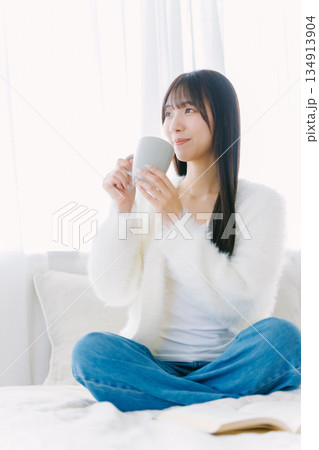 ベッドでコーヒーを飲む若い女性 ベッドでコーヒーを飲む若い女性 134913904