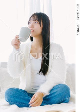ベッドでコーヒーを飲む若い女性 ベッドでコーヒーを飲む若い女性 134913906