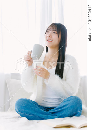 ベッドでコーヒーを飲む若い女性 134913912