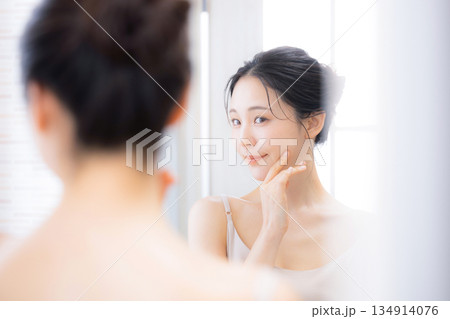 鏡を見るケアする女性　保湿とスキンケア	 134914076